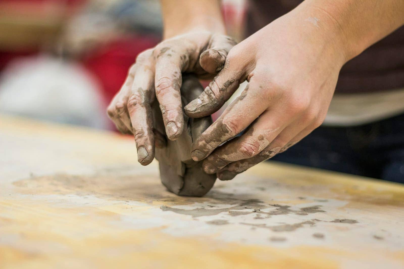 A potter's clay-stained hands at the wheel (Reference image, not a CHAYP project)